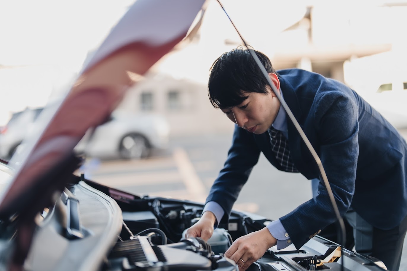 車のボンネットを確認するビジネスマン