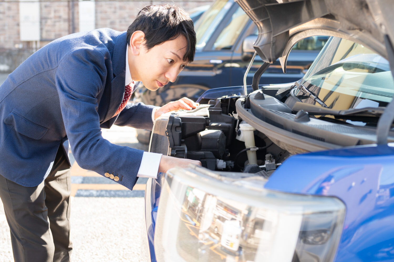 車のボンネットを確認している男性ビジネスマン