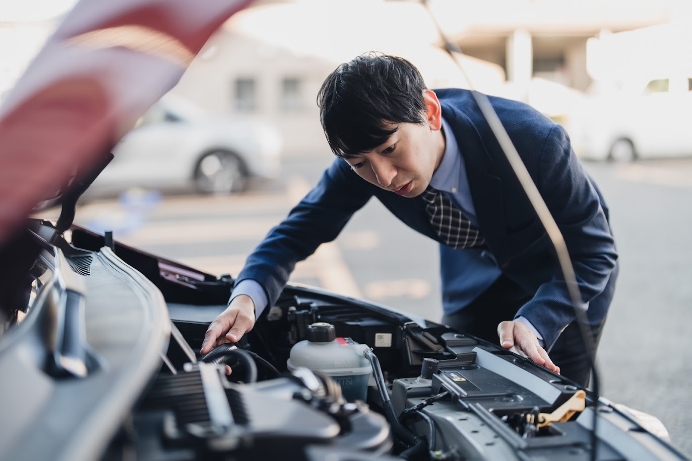 車のボンネットを点検するビジネスマン