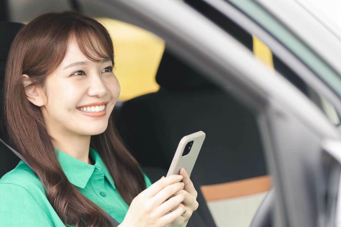 車内でスマホを持つ女性