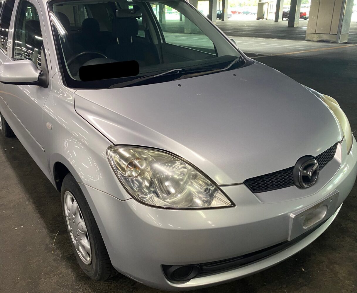 古い年式の銀色のマツダのデミオ